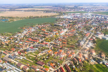 Obraz premium Aerial view of a suburban neighborhood with houses and gardens near green fields.