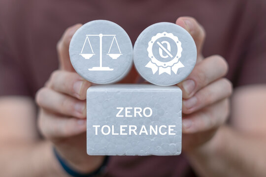 Zero tolerance concept. Person holding white blocks with icons sees the inscription ZERO TOLERANCE.