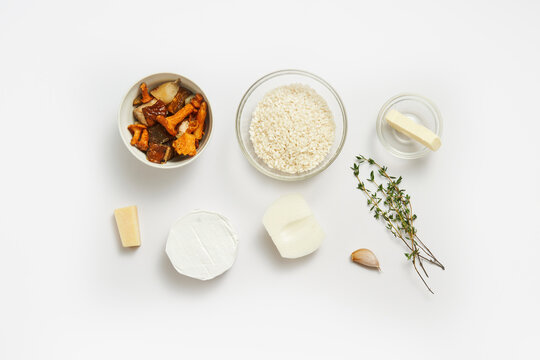 The image displays essential ingredients for making risotto, including rice, dried mushrooms, cheese, garlic, and fresh thyme