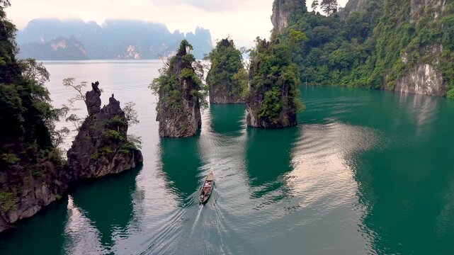 Journey over the stunning limestone cliffs and emerald waters of Khao Sok National Park Thailand. Experience the serene landscapes and vibrant nature, perfect for travel enthusiasts seeking adventure.