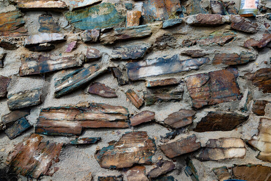 Textura de muro de piedra natural que simboliza fuerza, durabilidad, artesan&iacute;a y dise&ntilde;o arquitect&oacute;nico r&uacute;stico con tonos tierra. Primer plano de piezas de piedra irregulares incrustadas en mortero 