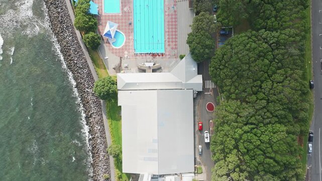 Aerial view of New Plymouth, Taranaki, New Zealand, offering a refreshing escape by the sea. People enjoy swimming in the pools.