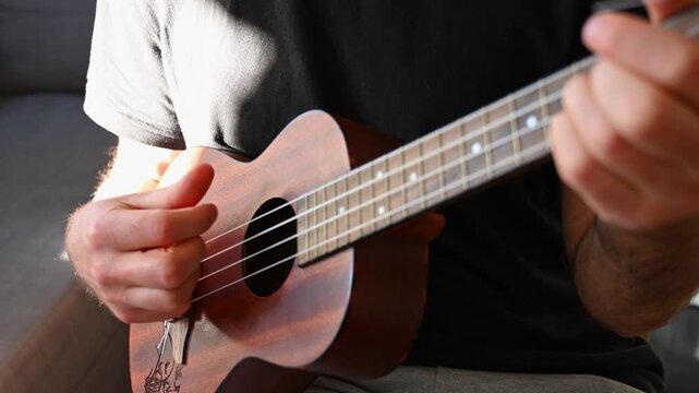 Man Strumming Ukulele Close Up