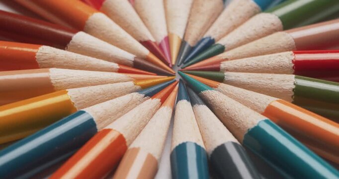 Slow motion close-up: multicolored sharpened pencils spin elegantly in a circle. Sharp tips and vibrant colors create dynamic visual effect, ideal for art supplies and creativity 4K.