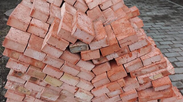 Stacked orange bricks arranged in a pyramid shape on a stone pavement, showcasing the gradual shift in perspective and alignment across the frames