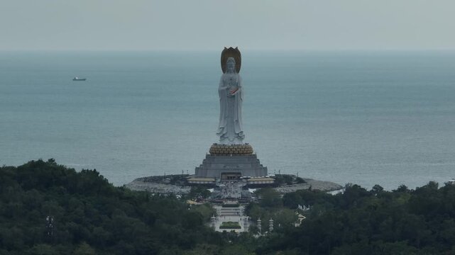 Aerial footage of Guanyin statue at seaside in nanshan temple, hainan island , China. Words mean mercy and blessing.
