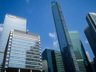 Naklejka premium Modern skyscrapers with reflective glass facades under blue sky