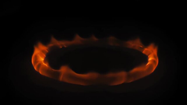 Circular fiery flame ring burning brightly against dark background, showing rapid ignition, intense expansion, and gradual fading of controlled fire. Artistic fire display footage