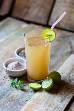 Jal Jeera Indian Summer Drink with Lime Slice Mint and Spices in Glass on Rustic Wooden Background