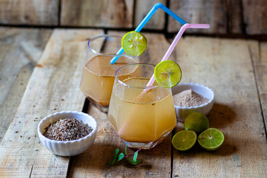Jal Jeera Indian Summer Drink with Lime Slice Mint and Spices in Glass on Rustic Wooden Background