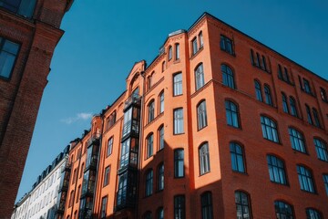 Fototapeta premium Red brick building with many windows under a bright blue sky