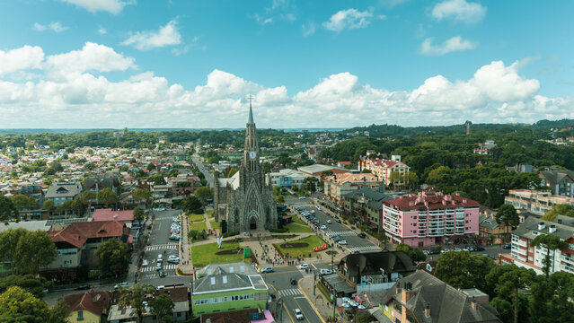 Vista a&eacute;rea da Catedral de Pedra no centro de Canela, Rio Grande do Sul, destacando a arquitetura neog&oacute;tica, o entorno urbano e a paisagem da Serra Ga&uacute;cha em dia ensolarado.