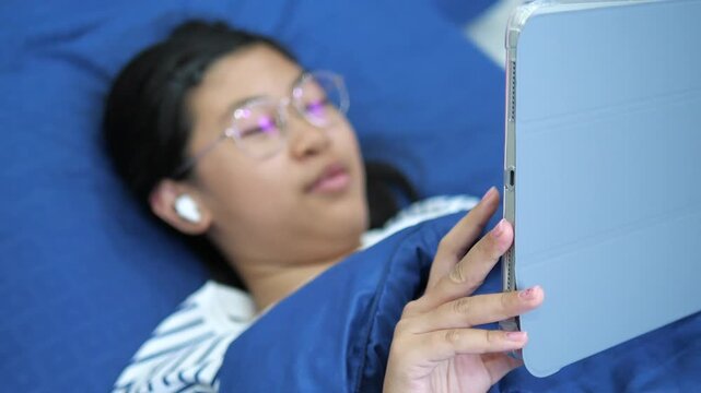 Close-up of young girl's hands holding a digital tablet with blurred face in background for online learning and mobile technology concept