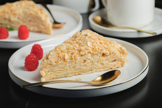 Sliced Napoleon cake on a white wooden table. Classic dessert