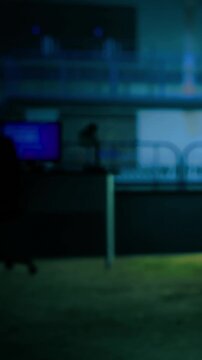 In a softly illuminated office, the glow from computer screens contrasts with the dark surroundings. Shadows dance on the walls, creating a sense of intrigue during late hours.