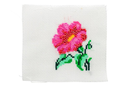 Cross-stitch embroidery on light fabric, macro, top view.
