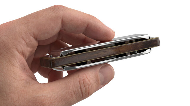 Hand holding a harmonica musical instrument close up.