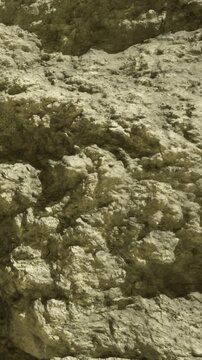 Sunlight casts interesting shadows on rugged rock formations, revealing intricate textures and patterns.