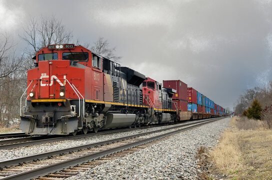 A Canadian National Railway intermodal freight train, with two locomotive units providing front-end power, thunders westbound through Durand, Michigan.