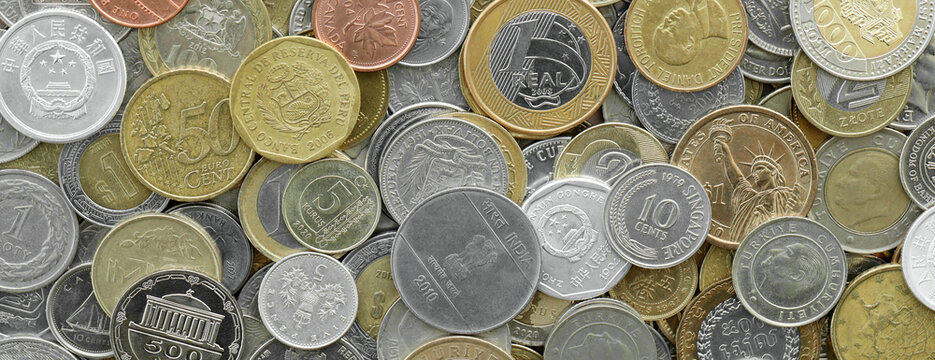 Top view of assorted coins, numerous world currencies together. Shiny metal pieces in mound
