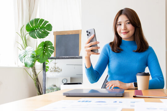 スマホを持ち笑顔の女性