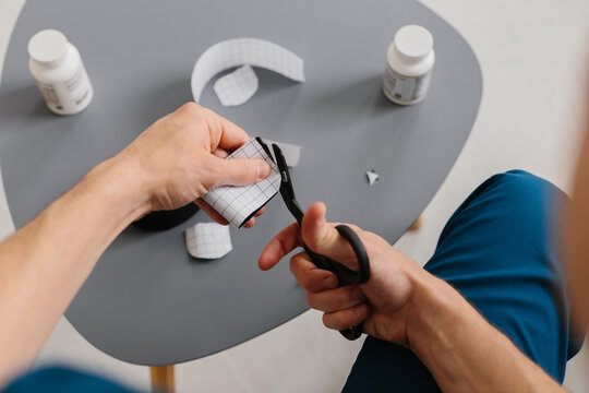 Orthopedic doctor preparing kinesiology tapes for application on a patient.