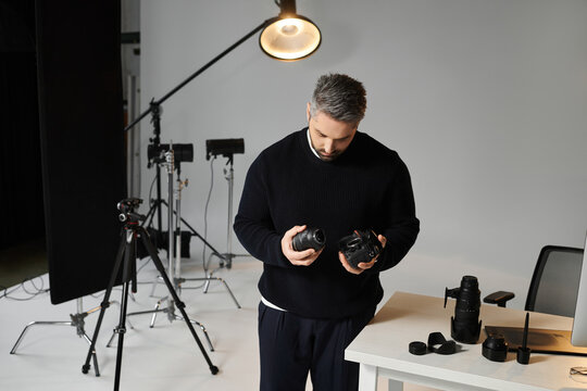 Creative man assessing camera equipment in a bright photography studio