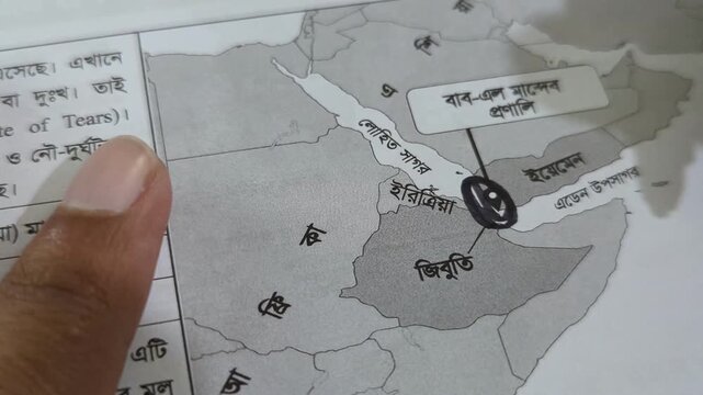 Person pointing at map with finger and then circling location with black pen marker for educational purpose in classroom setting during geography lesson showing red sea area and african coast.