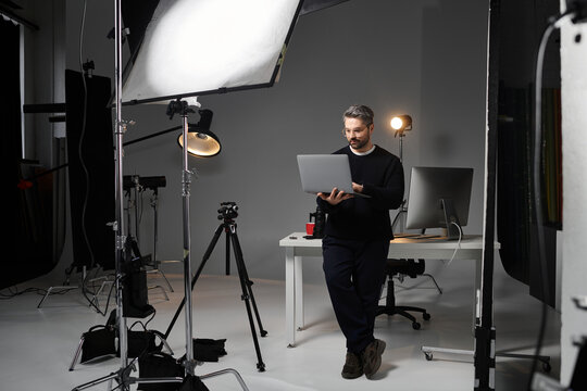 Creative photographer at work in a modern studio setting focused on digital editing tasks