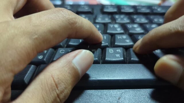 A close-up shot captures human hands typing rapidly on a black computer keyboard, emphasizing quick finger movements across the keys, creating dynamic and focused office or work footage.