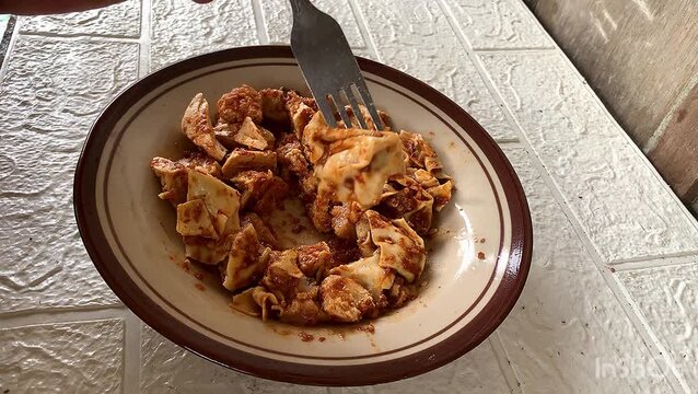 Indonesian steamed fish dumplings with spicy peanut sauce on a plate. eat with a fork. light dish.