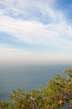 Calm sea horizon with distant ships and haze