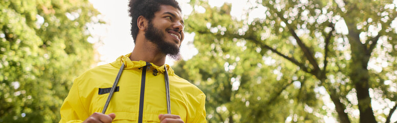 Vibrant workout in nature: young man in yellow windbreaker enjoying spring day © LIGHTFIELD STUDIOS