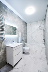 Contemporary bathroom interior with bathtub, suspended toilet and sink cabinet. Refined washroom...