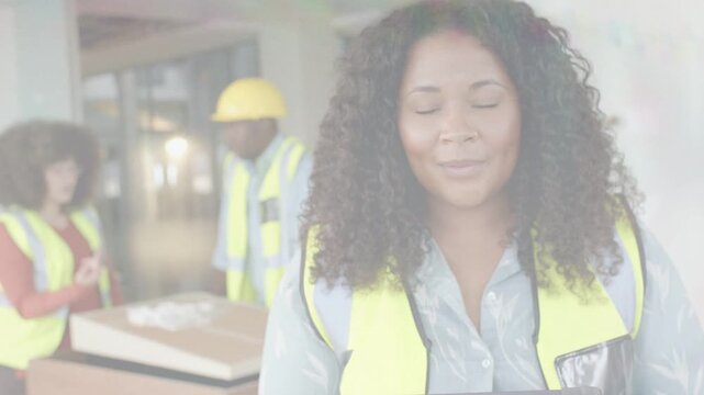 Site lead using tablet activating AR overlays with team reviewing plans, coordinating construction