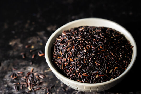 Jasberry, purple rice in a ceramic bowl on a dark surface 