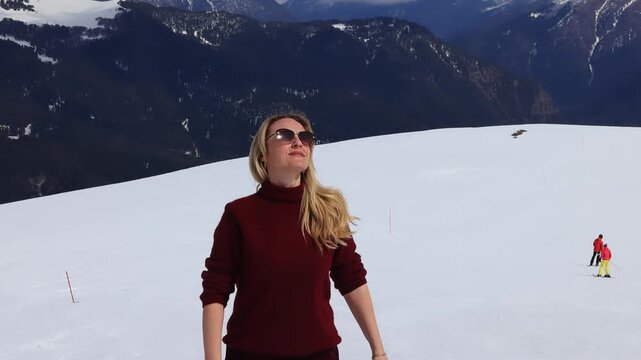 A girl against the backdrop of snowy mountain peaks.