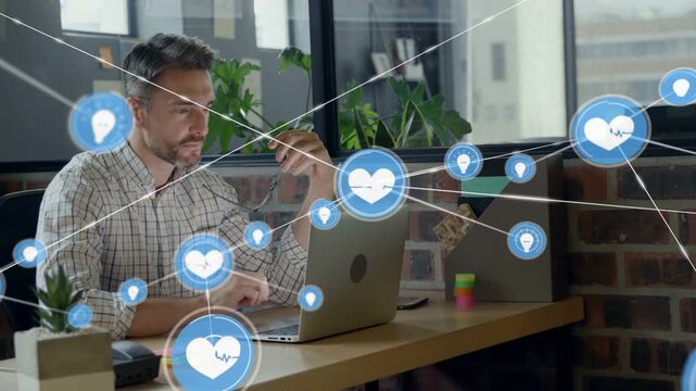 Watching blue heart popping on laptop, man in plaid shirt leaning typing at desk monitoring network