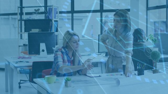 Spreading plans, two women pointing, tapping tablet at office desk for review, shirt, blue overlay