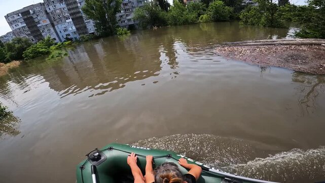 Volunteers evacuating people on boat after detonation of Kakhovka Hydroelectric Power Station. Flooding in Kherson town as a result of explosion of dam on Dnipro river in city of Novaya Kakhovka