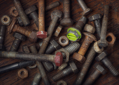 Various old nuts and bolts on an old workbench