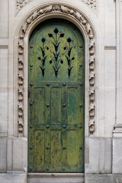 Green arched historic door with decorative metal detail