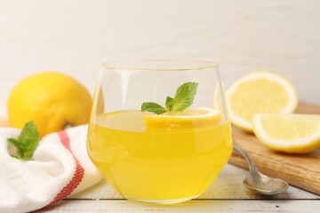 Fototapeta premium Tasty lemon jelly served with mint on white wooden table, closeup