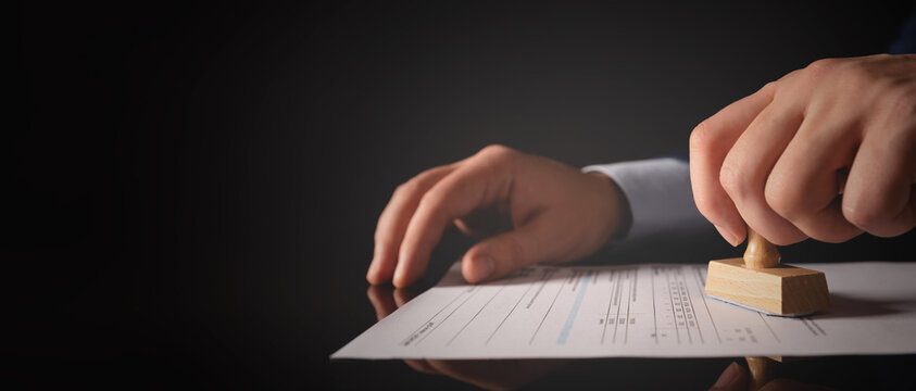 Businessman working in office with stamp