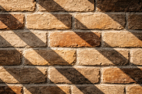 Textured brick wall with shadows and warm lighting effects