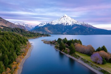 Obraz premium Majestic snow-capped mountain over serene lake and lush forest at sunrise