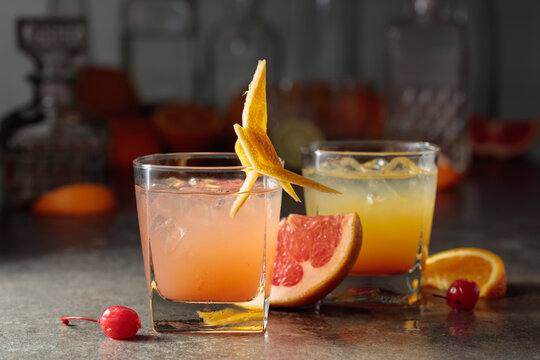Cocktails with ice, grapefruit juice, and orange juice garnished with maraschino cherry.
