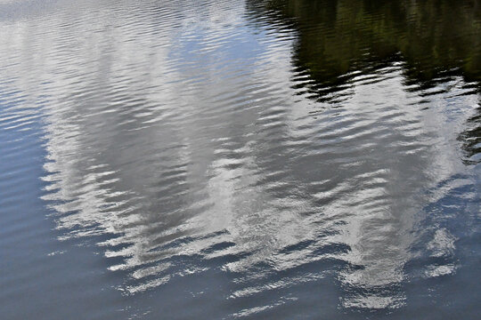 Diagonal ripples reflecting clouds in sky