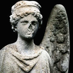 Fototapeta premium Angel statue isolated on black background, symbol of protection, spirituality and eternal peace.
