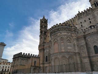 Fototapeta premium Palermo Cathedral featuring intricate architectural details and a prominent bell tower against a blue sky in Palermo, Sicily, Italy